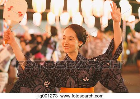 Stock Image - Young Japanese woman in a traditional kimono at a summer festival. Fotosearch