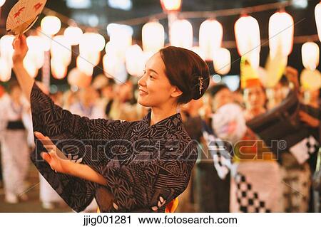 Stock Image - Young Japanese woman in a traditional kimono at a summer festival. Fotosearch