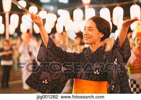 Stock Image - Young Japanese woman in a traditional kimono at a summer festival. Fotosearch