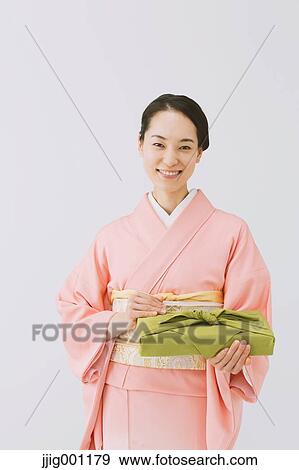 Stock Photo - Young Japanese woman in a traditional kimono against white background. Fotosearch