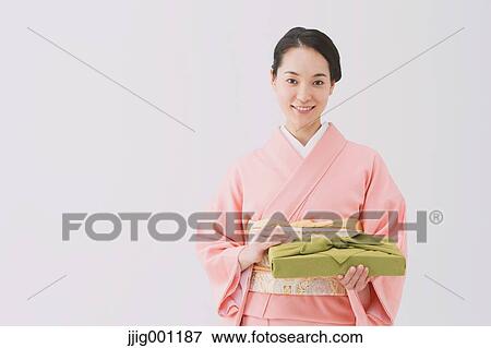 Stock Photo - Young Japanese woman in a traditional kimono against white background. Fotosearch
