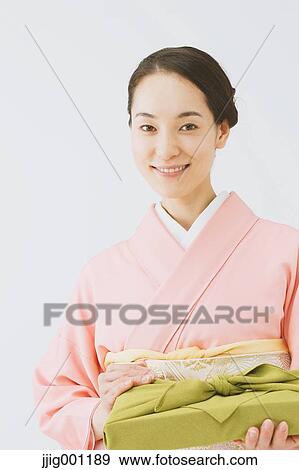 Stock Photo - Young Japanese woman in a traditional kimono against white background. Fotosearch
