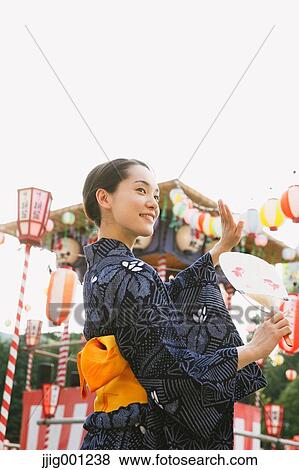 Young Japanese woman in a traditional kimono at a summer festival View Large Photo Image Stock Photo - Young Japanese woman in a traditional kimono at a summer festival. Fotosearch
