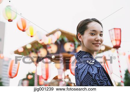 Stock Photo - Young Japanese woman in a traditional kimono at a summer festival. Fotosearch