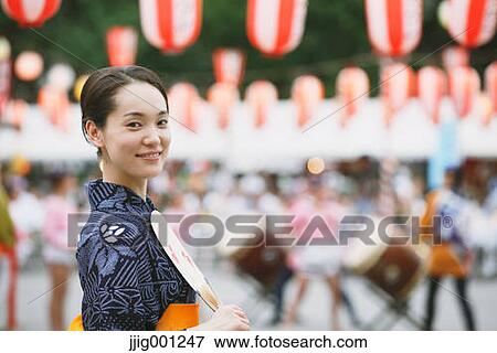 Stock Photo - Young Japanese woman in a traditional kimono at a summer festival. Fotosearch