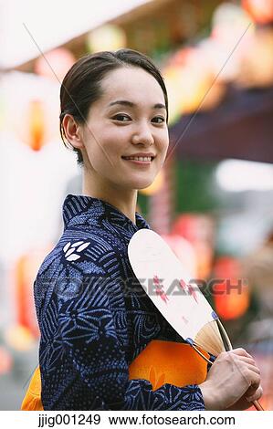 Young Japanese woman in a traditional kimono at a summer festival View Large Photo Image Stock Photo - Young Japanese woman in a traditional kimono at a summer festival. Fotosearch