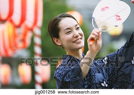 Young Japanese woman in a traditional kimono at a summer festival View Large Photo Image Stock Photo - Young Japanese woman in a traditional kimono at a summer festival. Fotosearch