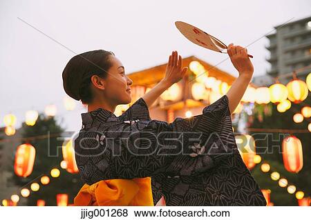 Stock Photo - Young Japanese woman in a traditional kimono at a summer festival. Fotosearch