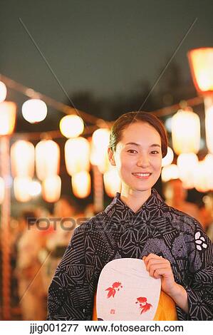 Young Japanese woman in a traditional kimono at a summer festival View Large Photo Image Stock Photo - Young Japanese woman in a traditional kimono at a summer festival. Fotosearch