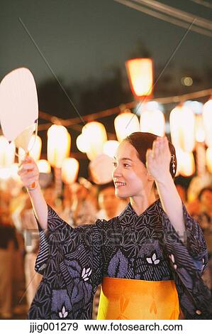 Stock Photo - Young Japanese woman in a traditional kimono at a summer festival. Fotosearch