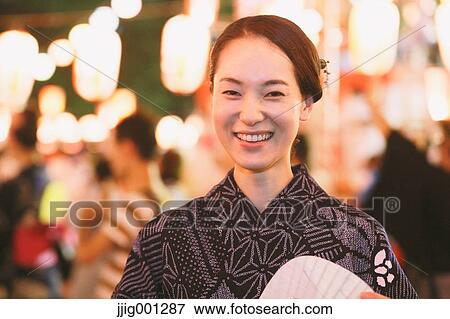 Stock Photo - Young Japanese woman in a traditional kimono at a summer festival. Fotosearch
