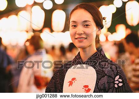 Stock Photo - Young Japanese woman in a traditional kimono at a summer festival. Fotosearch