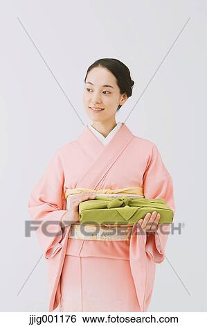Stock Photograph - Young Japanese woman in a traditional kimono against white background. Fotosearch