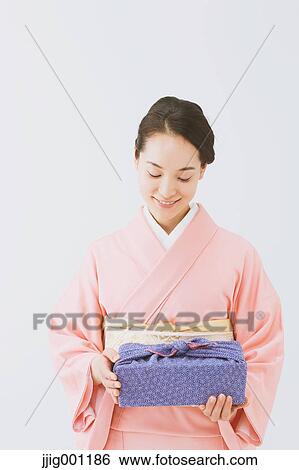 Stock Photograph - Young Japanese woman in a traditional kimono against white background. Fotosearch