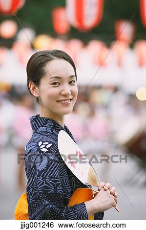 Stock Photograph - Young Japanese woman in a traditional kimono at a summer festival. Fotosearch