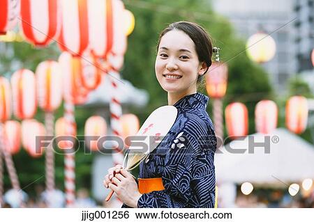 Stock Photograph - Young Japanese woman in a traditional kimono at a summer festival. Fotosearch
