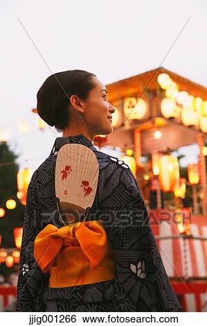 Young Japanese woman in a traditional kimono at a summer festival View Large Photo Image Stock Photograph - Young Japanese woman in a traditional kimono at a summer festival. Fotosearch