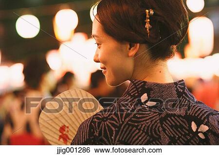 Stock Photograph - Young Japanese woman in a traditional kimono at a summer festival. Fotosearch