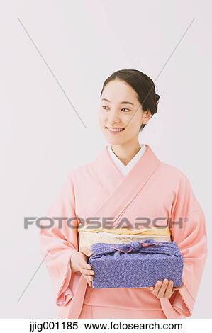 Young Japanese woman in a traditional kimono against white background View Large Photo Image Stock Photography - Young Japanese woman in a traditional kimono against white background. Fotosearch