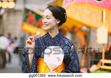 Stock Photography - Young Japanese woman in a traditional kimono at a summer festival. Fotosearch