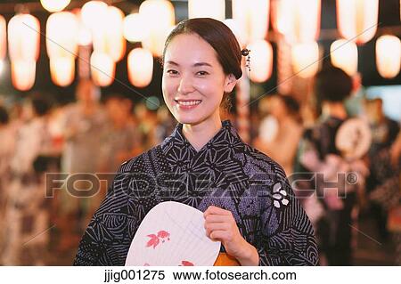 Stock Photography - Young Japanese woman in a traditional kimono at a summer festival. Fotosearch