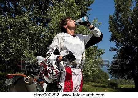 Stock Image - Young Man Relaxing After Dirt Bike Ride. Fotosearch