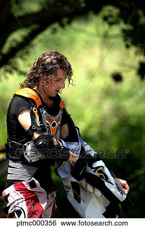 Stock Photograph - Young Man Relaxing After Riding Dirt Bike. Fotosearch