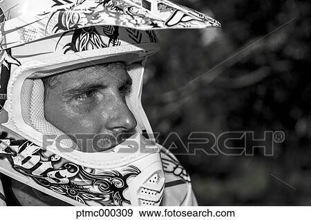 Stock Photo - Young Man Relaxing Besides Motocross Bike in Countryside. Fotosearch
