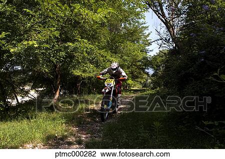 Stock Image - Young Man Riding Motocross Bike in Italian Countryside. Fotosearch