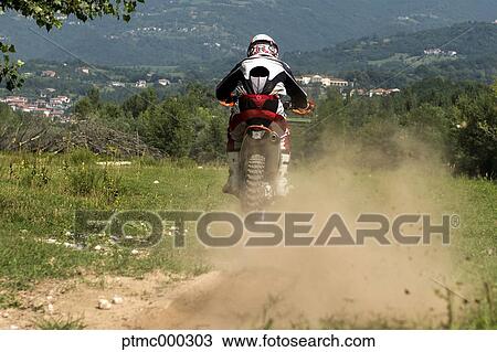 Stock Image - Young Man Riding Motocross Bike in Italian Countryside. Fotosearch