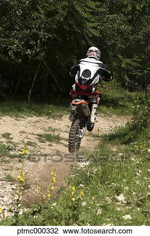 Stock Image - Young Man Riding Motocross Bike in Italian Countryside. Fotosearch