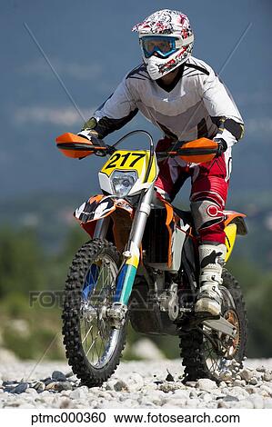 Stock Image - Young Man Riding Motocross Bike in Italian Countryside. Fotosearch