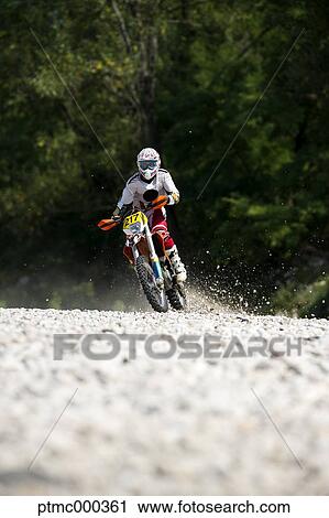 Stock Image - Young Man Riding Motocross Bike in Italian Countryside. Fotosearch