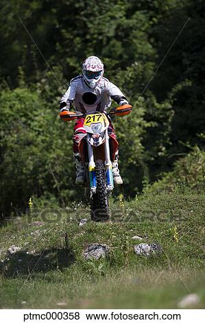 Stock Photo - Young Man Riding Motocross Bike in Italian Countryside. Fotosearch