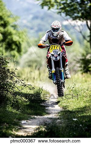 Stock Photo - Young Man Riding Motocross Bike in Italian Countryside. Fotosearch