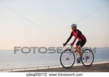 Stock Image - Young Japanese girl cycling. Fotosearch