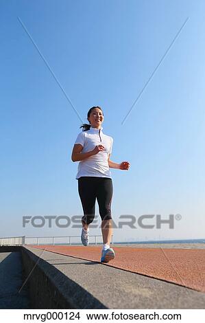 Picture - Young Japanese girl jogging. Fotosearch