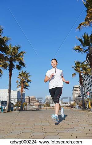 Picture - Young Japanese girl jogging. Fotosearch