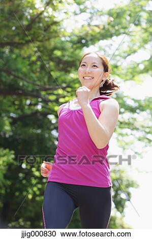 Stock Image - Young Japanese girl running in the park. Fotosearch