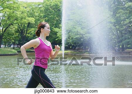 Stock Image - Young Japanese girl running in the park. Fotosearch
