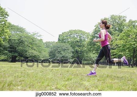Stock Image - Young Japanese girl running in the park. Fotosearch