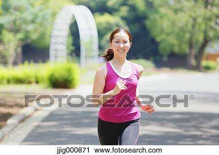 Stock Image - Young Japanese girl running in the park. Fotosearch