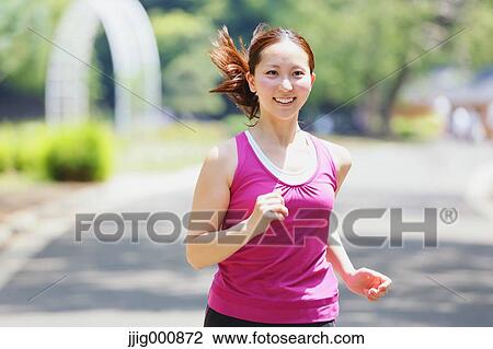 Stock Image - Young Japanese girl running in the park. Fotosearch