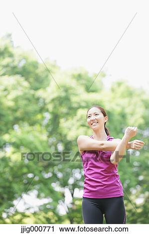 Young Japanese girl stretching in the park View Large Photo Image Stock Image - Young Japanese girl stretching in the park. Fotosearch