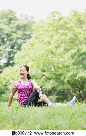 Stock Image - Young Japanese girl stretching in the park. Fotosearch
