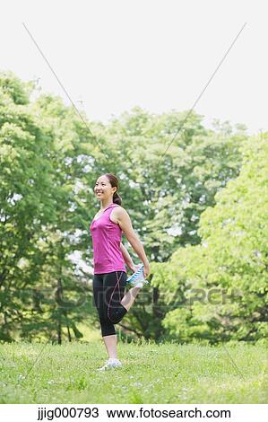 Stock Image - Young Japanese girl stretching in the park. Fotosearch
