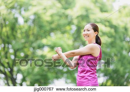 Young Japanese girl stretching in the park View Large Photo Image Stock Photo - Young Japanese girl stretching in the park. Fotosearch