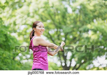 Young Japanese girl stretching in the park View Large Photo Image Stock Photo - Young Japanese girl stretching in the park. Fotosearch