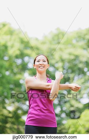 Young Japanese girl stretching in the park View Large Photo Image Stock Photo - Young Japanese girl stretching in the park. Fotosearch