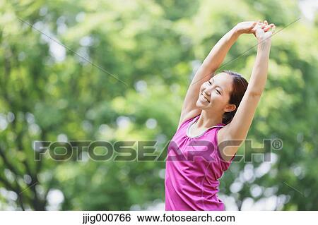 Stock Photograph - Young Japanese girl stretching in the park. Fotosearch